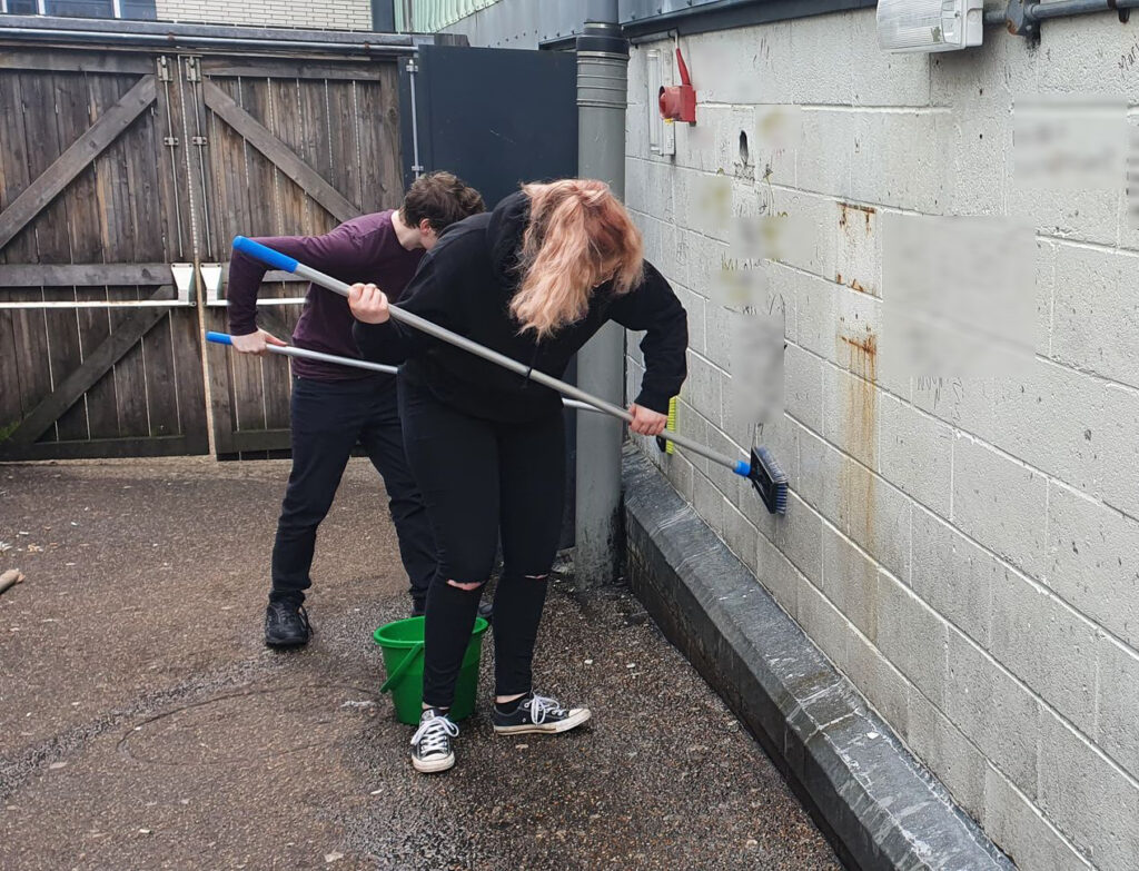 Debate members clean a wall.